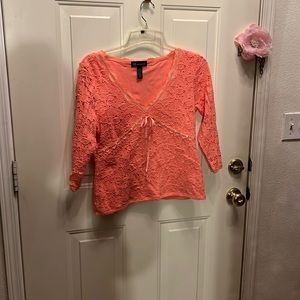Coral colored blouse with lace like pattern. Size large.